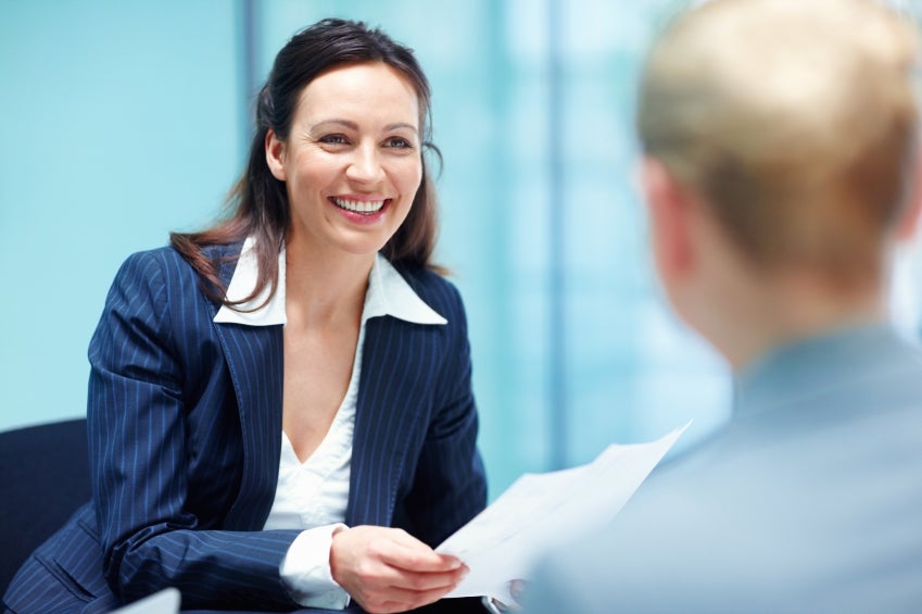 Smiling business woman conversing with executive