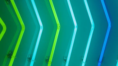 green and blue illuminated lights in triangles facing right